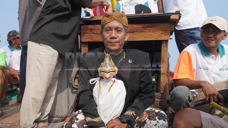 Suasana semakin khidmat dengan kehadiran seorang dalang yang mengiringi perjalanan di atas kapal sambil memainkan wayang golek.