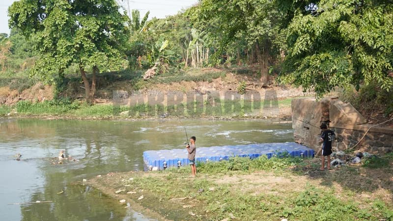 Anak-anak memancing di sepanjang tepian Sungai Angke (Foto: PARBOABOA/Defri Ngo)