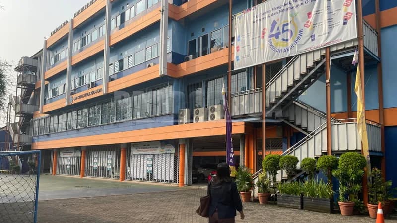 Seorang guru memasuki pelataran salah satu sekolah swasta di Jakarta Barat (Foto: PARBOABOA/Defri Ngo)