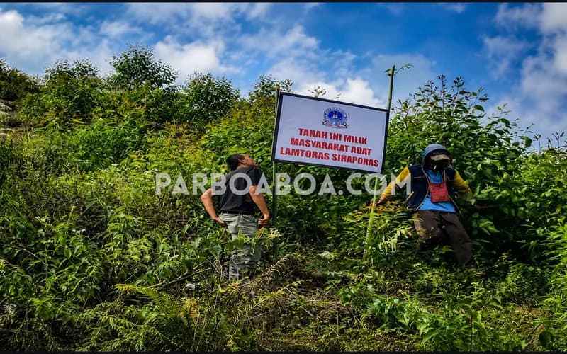 Masyarakat adat Lamtoras Sihaporas memasang pelang penanda wilayah adat. (Foto: Fidel Castro Ambarita/PARBOABOA)
